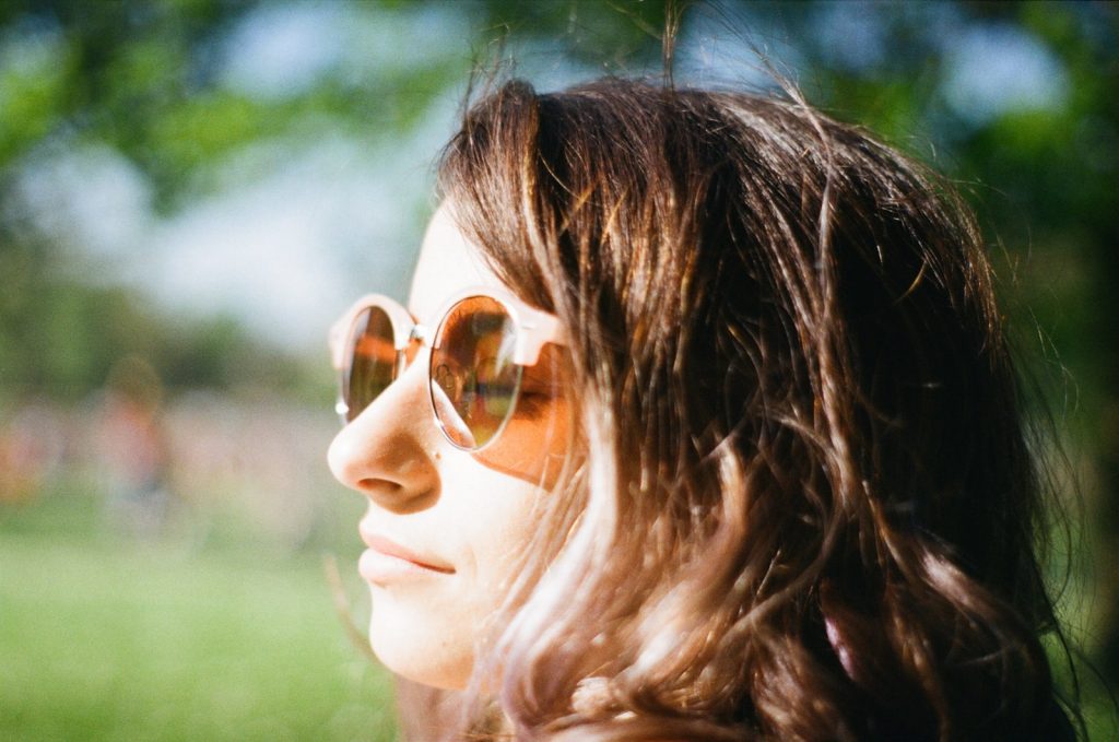 woman closing her eyes wearing brown lens sunglasses