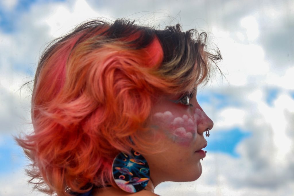 woman with red hair wearing blue and white floral earring